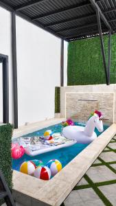 a swimming pool with an inflatablelatable unicorn and balls at White House Cabo in Cabo San Lucas