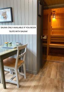 a table and a chair next to a sauna only available if you book at Highland Rooms - Room Only No Breakfast in Ullapool