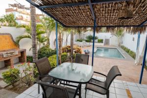 a patio with a table and chairs and a swimming pool at 2BR Steps to Malecón Panoramic views Private pool in La Paz +29 photos