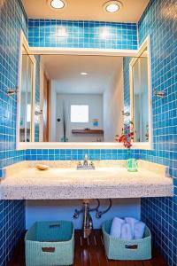 a blue tiled bathroom with a sink and a mirror at 2BR Steps to Malecón Panoramic views Private pool in La Paz