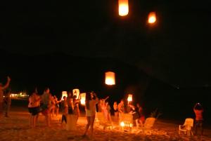 a group of people standing on the beach at night at Bottle Beach 2 Bungalows in Bottle Beach