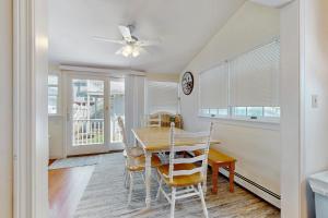 ein Esszimmer mit Tisch und Stühlen und einem Deckenventilator in der Unterkunft Hen Cove Cottage in Pocasset