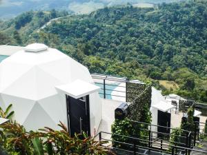a white house with a view of a mountain at Sunrise Hill Glamping in San Juan +136 photos