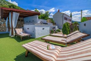 un groupe de chaises longues assises sur une pelouse dans l'établissement House Bozica with sauna and pool, à Tribalj