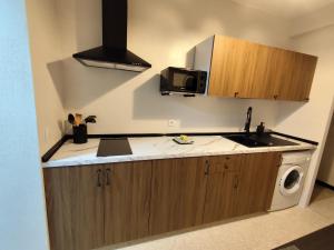 a kitchen with a sink and a microwave at El Corazón de Gredos II in Arenas de San Pedro +8 photos