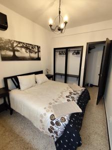 a bedroom with a bed and a chandelier at El Corazón de Gredos II in Arenas de San Pedro