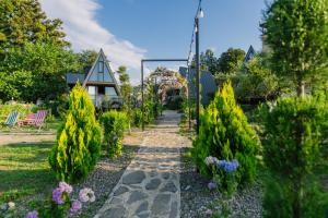 a garden with trees and flowers and a house at La'Familia in Batumi