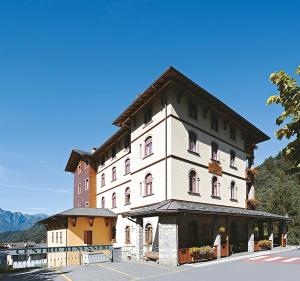 a large white building with a clock tower at Albergo Piazzatorre in Piazzatorre