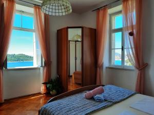 a bedroom with a bed and two windows at Apartments Kirigin in Dubrovnik +36 photos