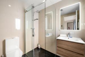 a bathroom with a toilet and a sink and a shower at Paihia Waterfront Apartment 2 Bedroom with Pool in Paihia +5 photos