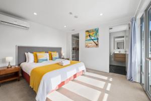a bedroom with a large bed and a bathroom at Paihia Waterfront Apartment 2 Bedroom with Pool in Paihia