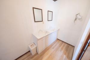 a white bathroom with a sink and two mirrors at Backpacker's House Kamome in Fujiyoshida +20 photos