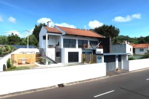 a white house on the side of a street at Seacrets Beach House in Praia do Almoxarife