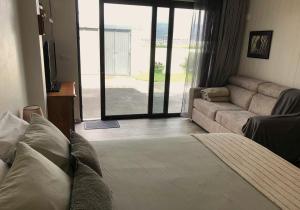 a living room with a couch and a living room with a television at Seacrets Beach House in Praia do Almoxarife
