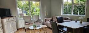 a living room with a table and chairs and a television at De Kleine kriemelkuil-Het Koentje in Ermelo