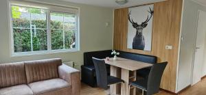 a dining room with a table and a couch at De Kleine kriemelkuil-Het Koentje in Ermelo