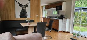 a kitchen and living room with a table and a deer picture on the wall at De Kleine kriemelkuil-Het Koentje in Ermelo