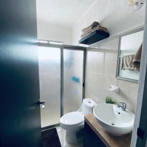 a bathroom with a white toilet and a sink at Casa venue in Mérida