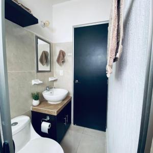 a bathroom with a white toilet and a sink at Casa venue in Mérida