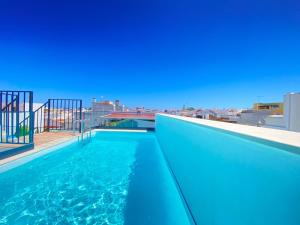 a swimming pool on the roof of a building at Mar-Ria 6 in Fuzeta