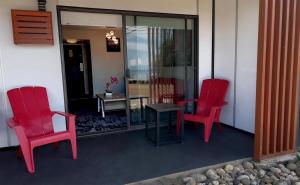 dos sillas rojas y una mesa en un porche en The Oceanside, a Coast Hotel, en Sechelt 15 fotos más