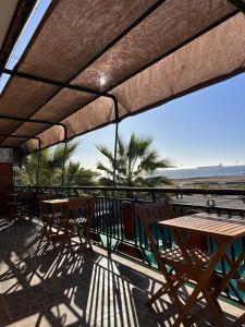 卡尔德拉Hostal El Ancla的一个带桌椅的庭院,享有海滩美景