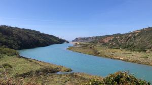 a river in the middle of a valley at Sudoeste Guest House in Odeceixe