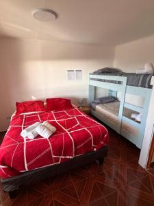 卡尔德拉Hostal El Ancla的一间卧室配有红色的床和一张双层床。