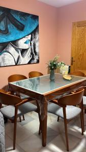 einen Esstisch mit Stühlen und ein Gemälde in der Unterkunft Vista Hermosa Costa Granada in Castell de Ferro