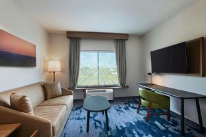 a living room with a couch and a desk in a hotel room at Fairfield Inn & Suites by Marriott Harlingen in Harlingen