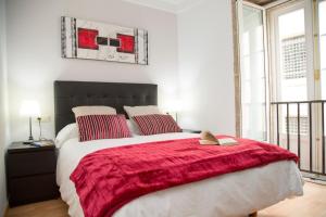 - une chambre avec un grand lit et une couverture rouge dans l'établissement Xavestre Rooms Santiago, à Saint-Jacques-de-Compostelle