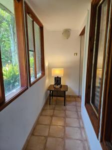 a hallway with a table with a lamp and windows at Къщи за гости Кедър in Varna City