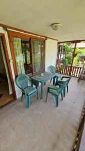 a patio with a table and chairs on a porch at Къщи за гости Кедър in Varna City +11 photos