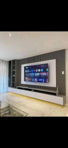 a room with a large flat screen tv on a wall at Tranquillity Cosy Lodge in Lilongwe