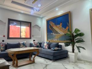 a living room with a couch and a table at Appartement near the airport in Deroua