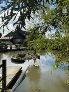 a body of water with a dock and a house at Footpath Cottages 