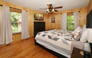 a bedroom with a bed and a ceiling fan at Cozy Bear Camp in Sevierville