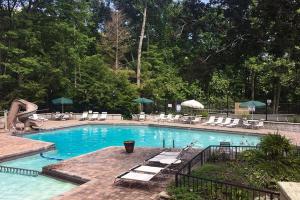 a large swimming pool with lounge chairs and umbrellas at Coppertop View in Gatlinburg