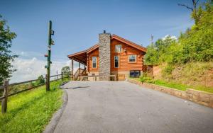 a wooden house on a road with a fence at Lifes a Bear in Gatlinburg