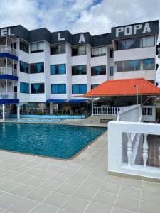 a hotel with a swimming pool in front of a building at Hotel la popa in Honda +10 photos
