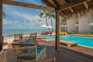 an outdoor patio with a swimming pool and the ocean at Moana Sands Lagoon Resort - Adults Only in Rarotonga