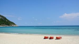 three boats sitting on a beach near the ocean at Bottle Beach 2 Bungalows in Bottle Beach