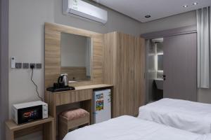 a small room with two beds and a mirror at Taibah Guide Apartments in Al Madinah +10 photos