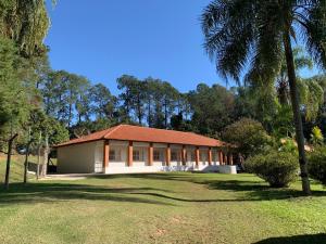 a building with a red roof in a park at Chácara Santa Maria in Itupeva