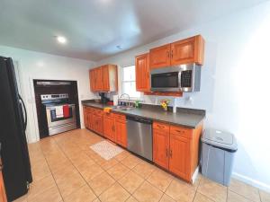 a kitchen with wooden cabinets and stainless steel appliances at Cozy 5 bedroom Home mins from RIT in Rochester