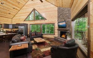 a living room with leather furniture and a fireplace at Rustic Timber in Sevierville
