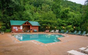 a swimming pool with a cabin in the background at Rustic Timber in Sevierville