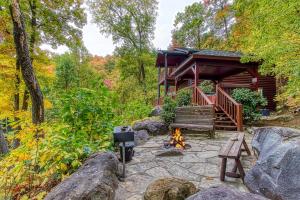 une cabine dans les bois avec un feu devant elle dans l'établissement Timberwinds 1804, à Gatlinburg