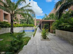 a courtyard with palm trees and a building at Homu Apartments in Mérida