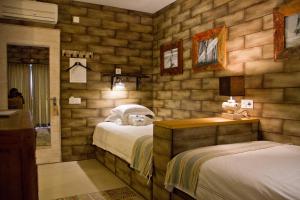 um quarto com 2 camas num quarto com paredes de madeira em Surfers Lodge Peniche em Peniche